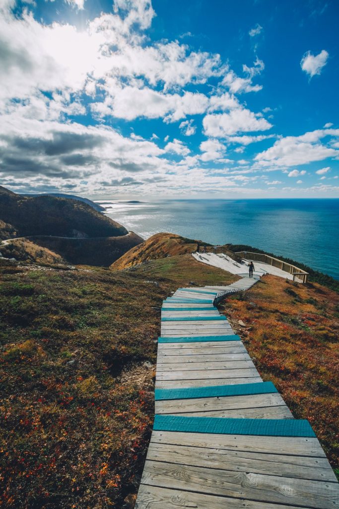passerella in legno con vista sull'oceano a Cape Breton Island durante il foliage autunnale